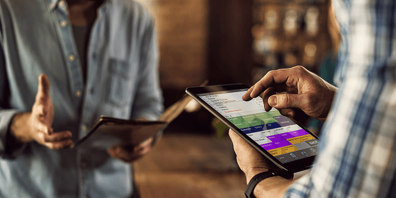 Waiter at table taking order with tablet