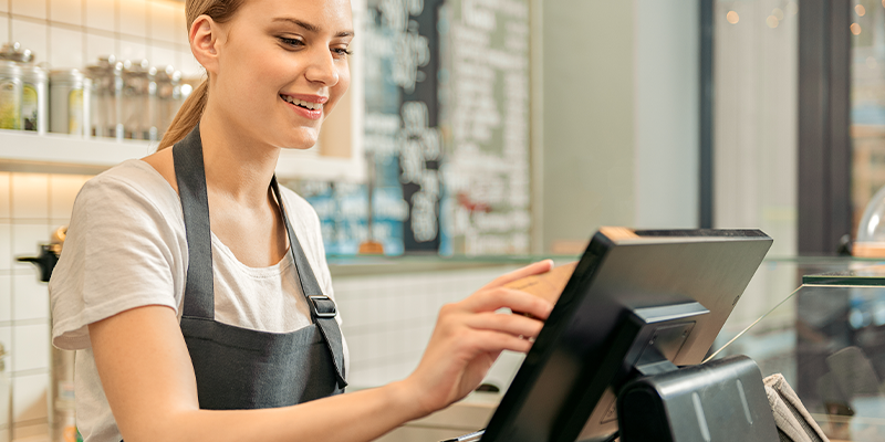 woman using till in shop