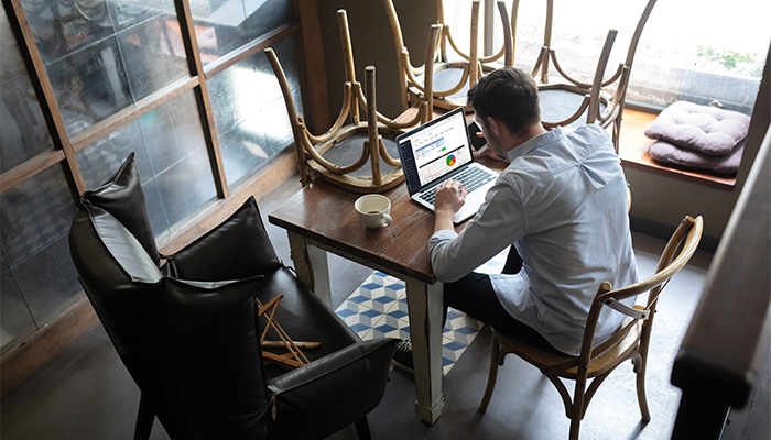 Bar manager sat at the table using laptop with TouchOffice Web software by ICRTouch