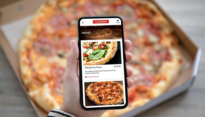 Phone holding up infront of pizza displaying TouchTakeaway ICRTouch software
